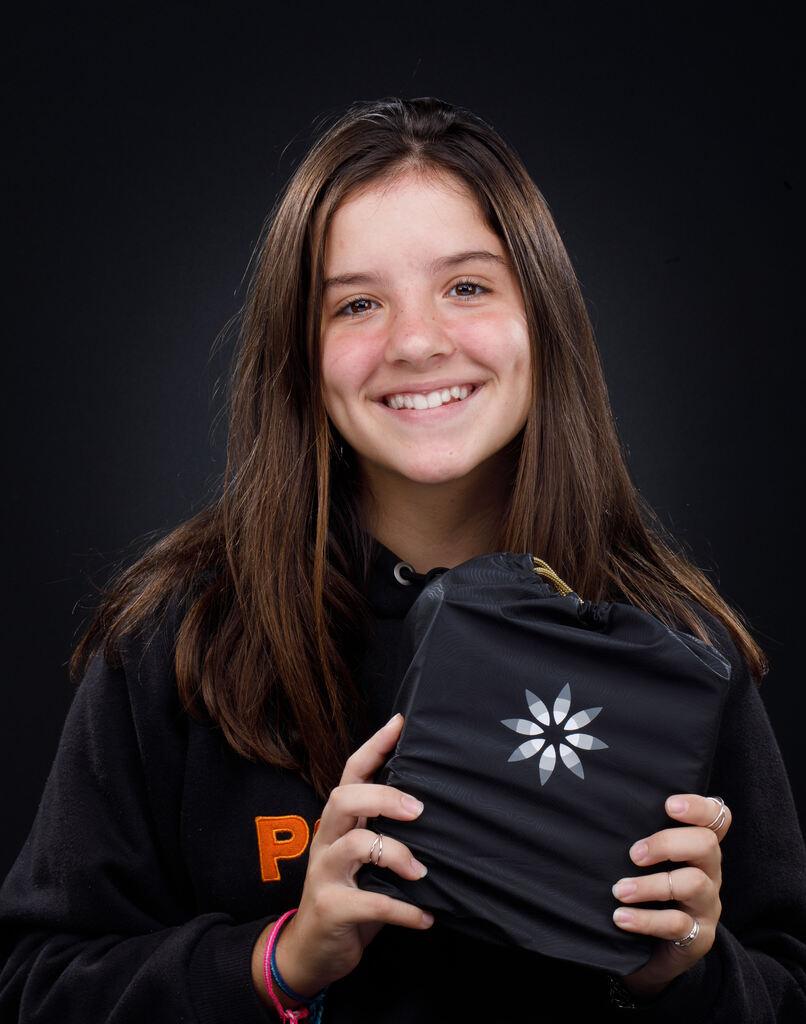 Paciente sorrindo segurando kit de alinhadores Invisalign em clínica odontológica especializada em Invisalign em Joinville.
