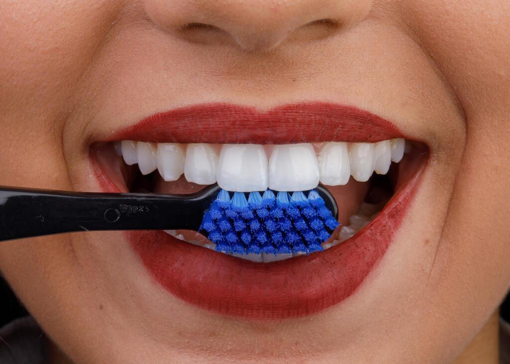 Técnica correta de escovação dental mostrando o posicionamento ideal da escova nos dentes