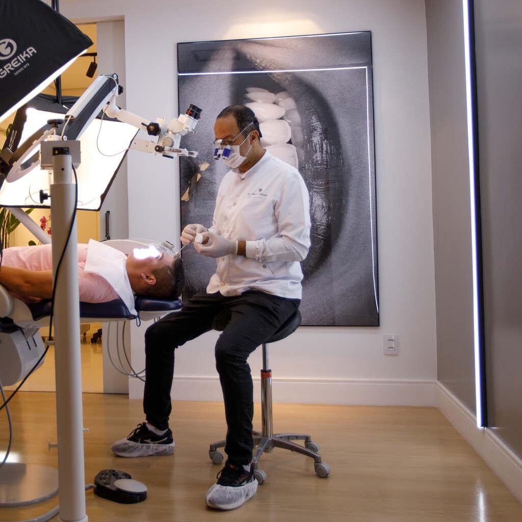 Dentista realizando tratamento de periodontite com equipamento odontológico