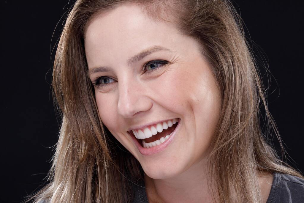 Paciente sorrindo após tratamento estético com faceta dental.